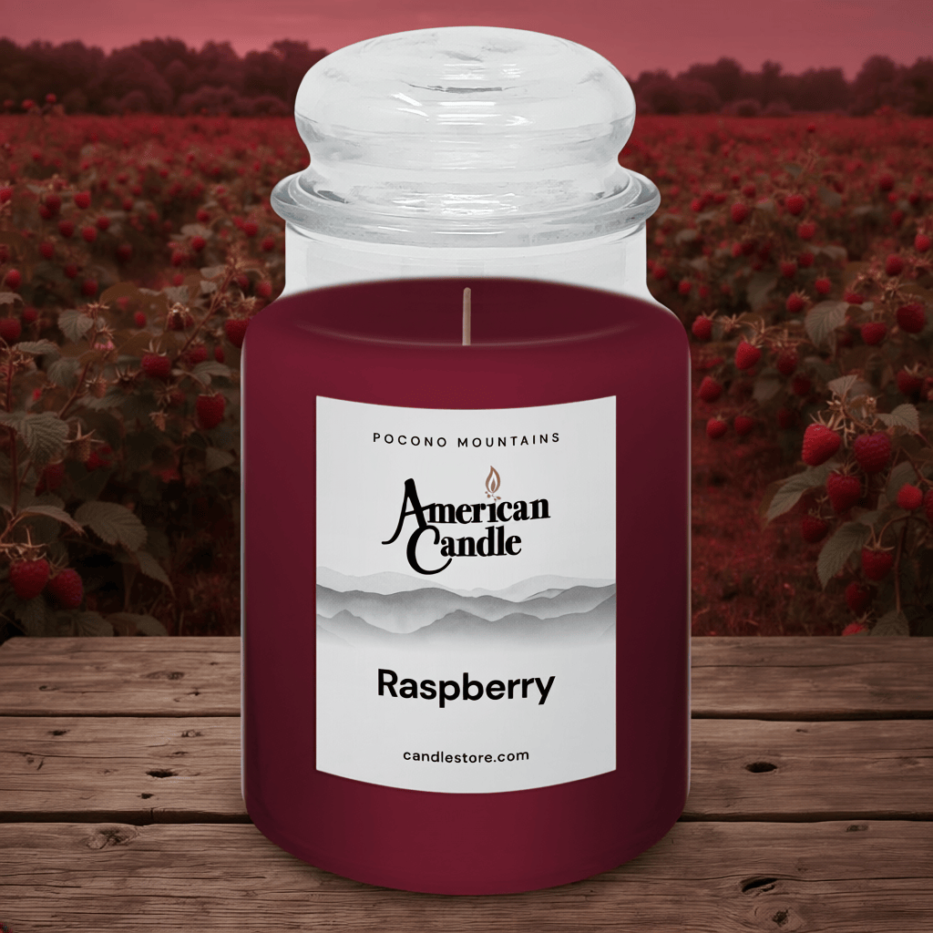 American Candle Raspberry jar scented candle on wooden table with raspberry field background
