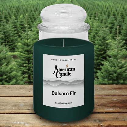 American Candle Balsam Fir scented jar candle with pine forest background on wooded table