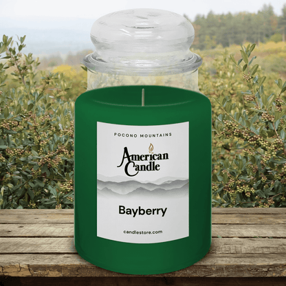 American Candle Bayberry Scented Jar Candle on a Wooden Table  with Bayberry Orchard in Background