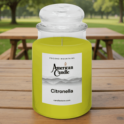 American Candle Citronella Scented Jar Candle on a wooden table with a park background
