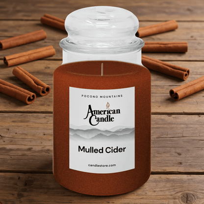 American Candle Mulled Cider Scented Jar Candle on a Wooden Table with Mulled Cider Sticks on the Table