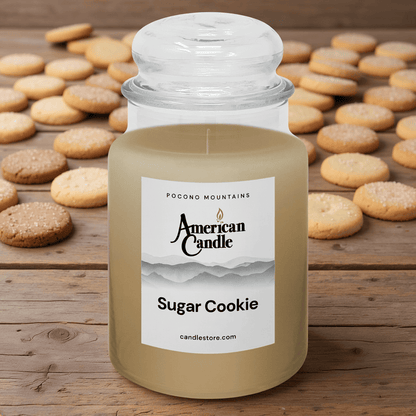 American Candle Sugar Cookie Scented Jar Candle on a Wooden Table with Sugar Cookies on the Table