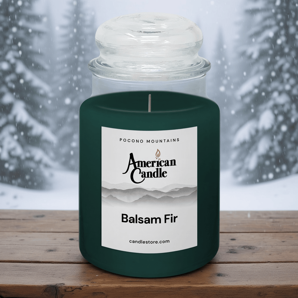American Candle Balsam Fir scented jar candle on a wooden table with a snowy forest background