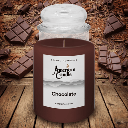 American Candle Chocolate-scented jar candle on a wooden stable with chocolate pieces