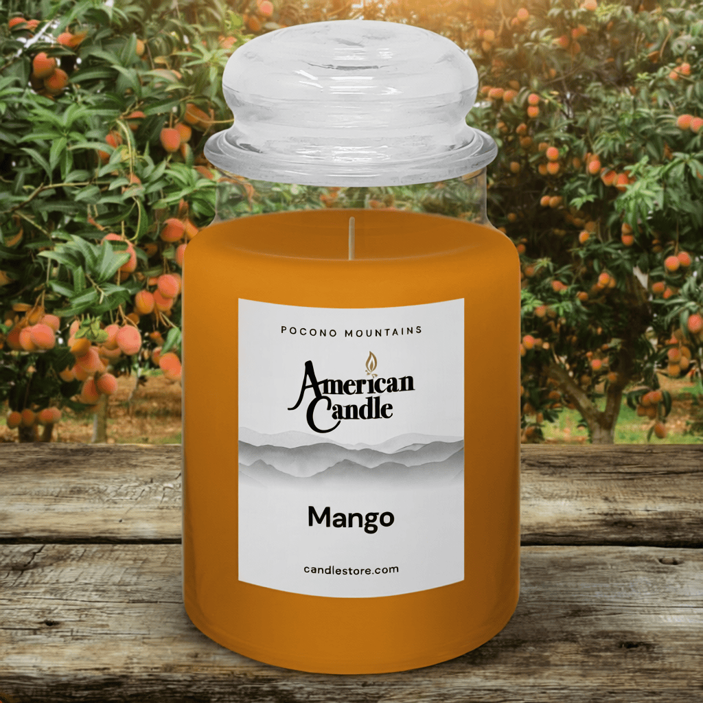 American Candle Mango scented jar candle with an orchard background on wooden table
