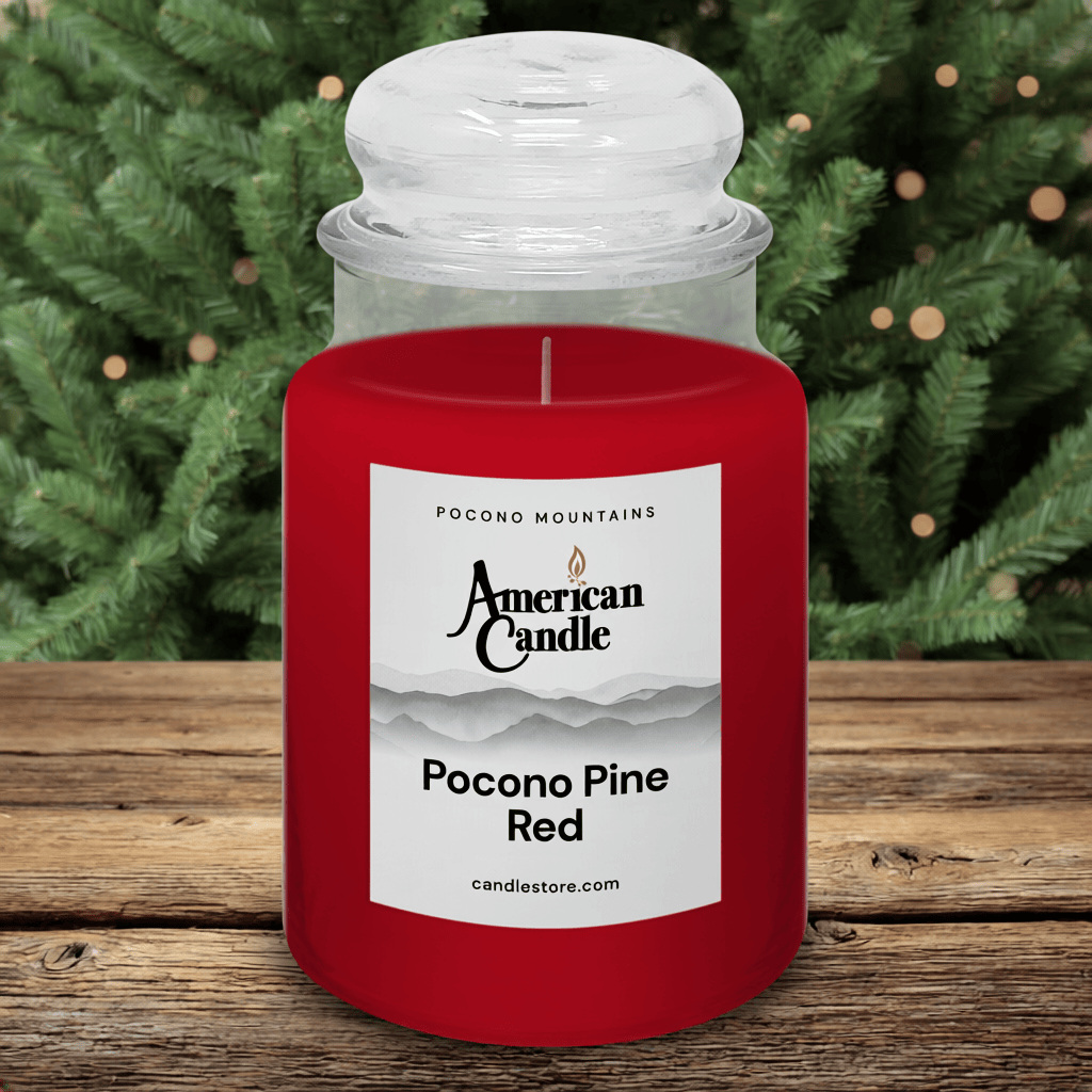 American Candle Pocono Pine Red Scented Jar Candle on wooden table with Pocono Pines Trees in background