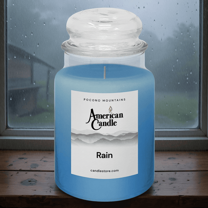 American Candle Rain Scented Jar Candle on a wooden table with a rainy window background