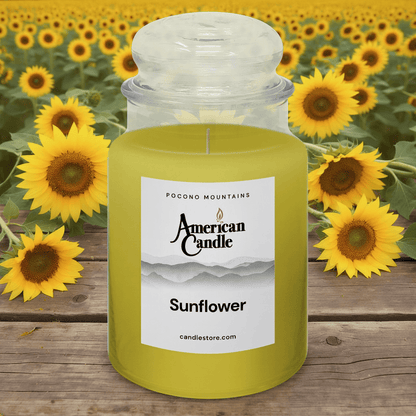 American Candle Sunflower Jar scented candle on wooden table in front of sunflowers
